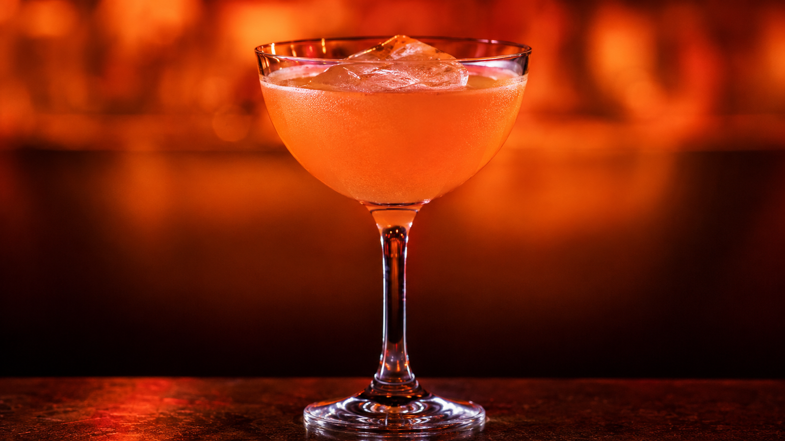 Naked and Famous vor extrem unscharfem Neonhintergrund in der Farbe des Drinks